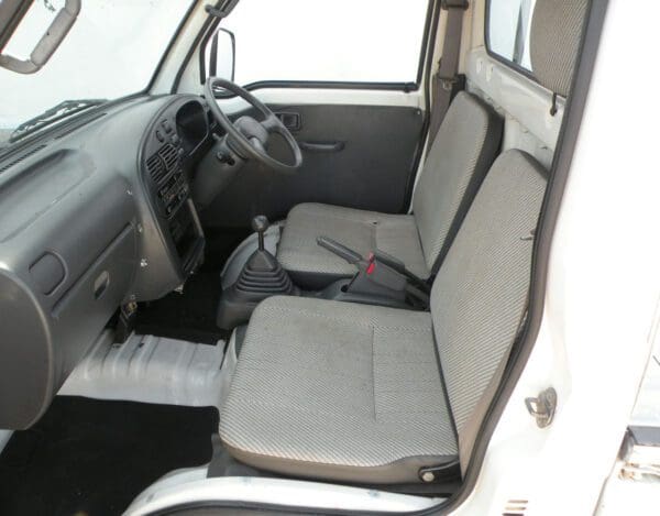 A truck with two seats and one of the seat belts.