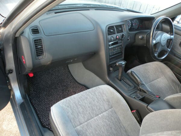 A car with the dashboard and front seats in a vehicle.