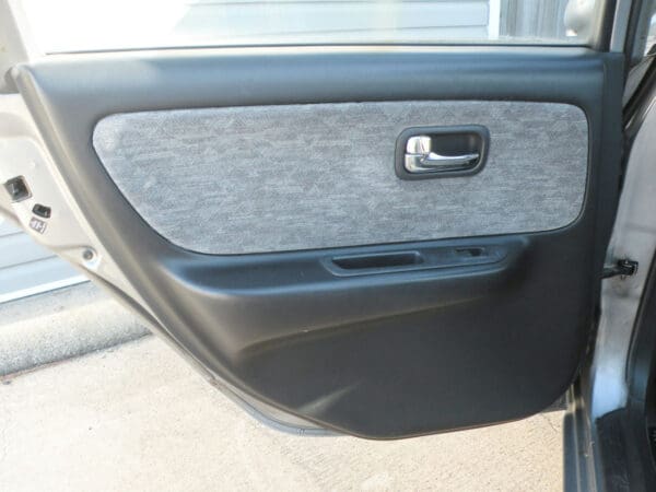 A car door with the handle and window open.