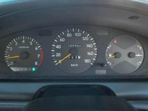 A dashboard of an automobile with the speedometer lit up.