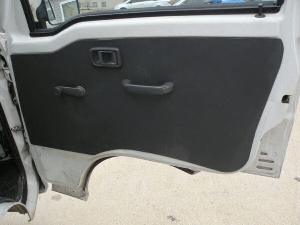 A door of an automobile with the handle raised.