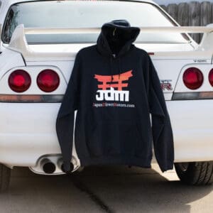 A hoodie that is hanging on the back of a car.