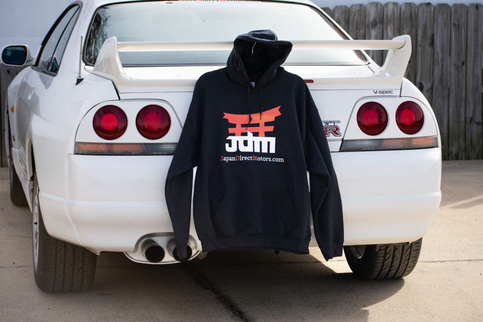 A hoodie that is hanging on the back of a car.