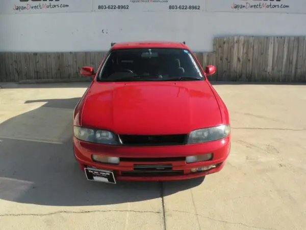 Red Nissan Skyline R33 front view.