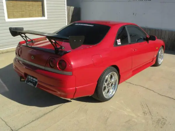 Red Nissan Skyline with rear wing.