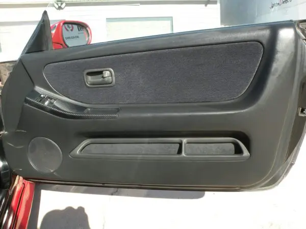 Black car door panel with speaker.