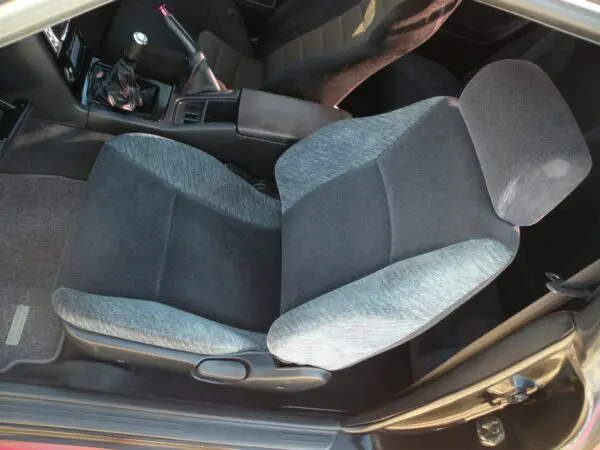 Grey fabric car seat with headrest.