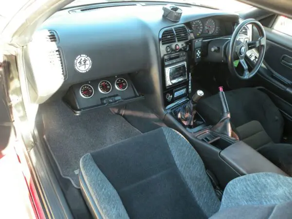 Black car interior with gauges and steering wheel.