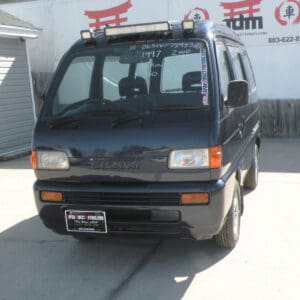 Black Suzuki van with a roof rack.