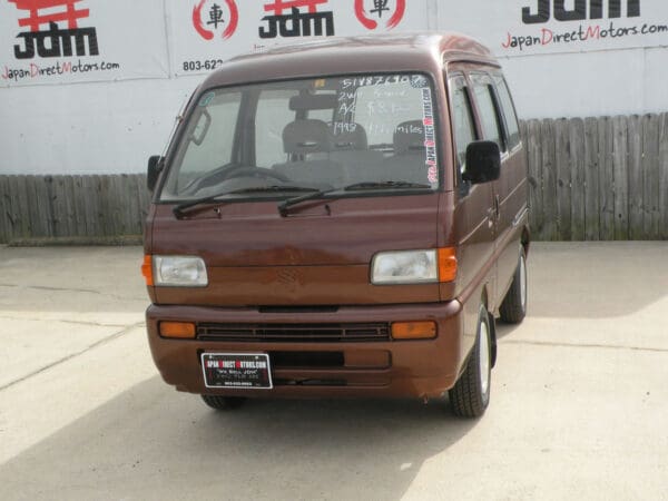 Brown van with black bumper and wheels.