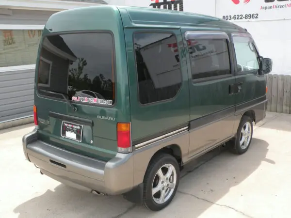 Green Subaru van parked on pavement.