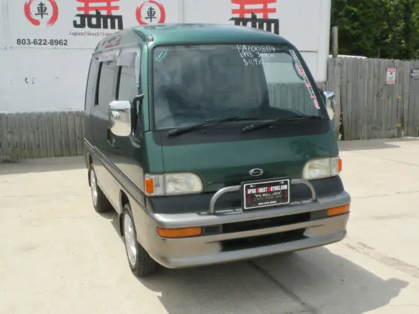 Green Subaru minivan with front bumper guard.