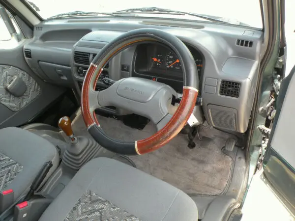 Subaru car interior with wooden steering wheel.