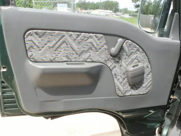 Gray car door with patterned panel.