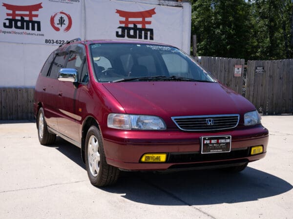 Red Honda Odyssey minivan front view.