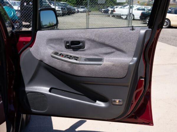 Red car open door interior detail.