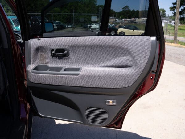 Red car's open passenger door interior.