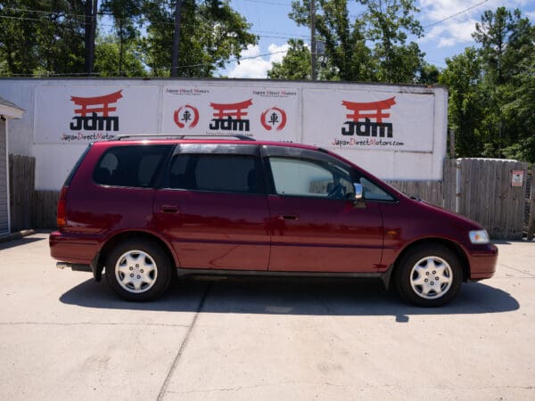 Red Honda Odyssey minivan parked outdoors.