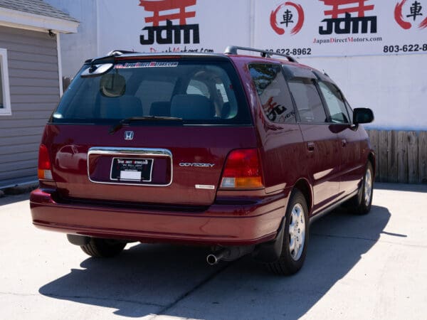 Red Honda Odyssey minivan rear view.