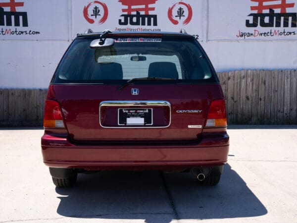 Red Honda Odyssey minivan rear view.