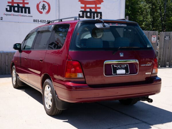 Red Honda Odyssey minivan rear view.