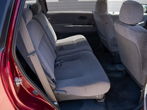 Grey cloth seats in a red car.