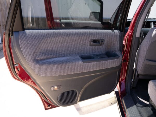 Red car door interior with gray fabric.