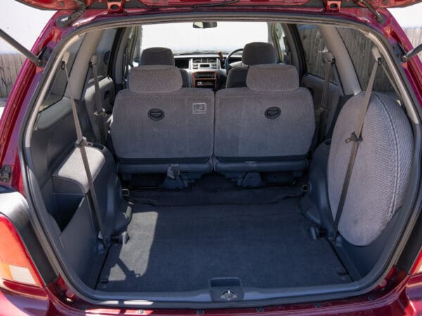 Red minivan with empty back seats.