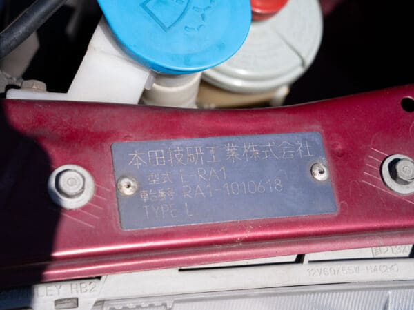 Vehicle identification plate with Japanese text.