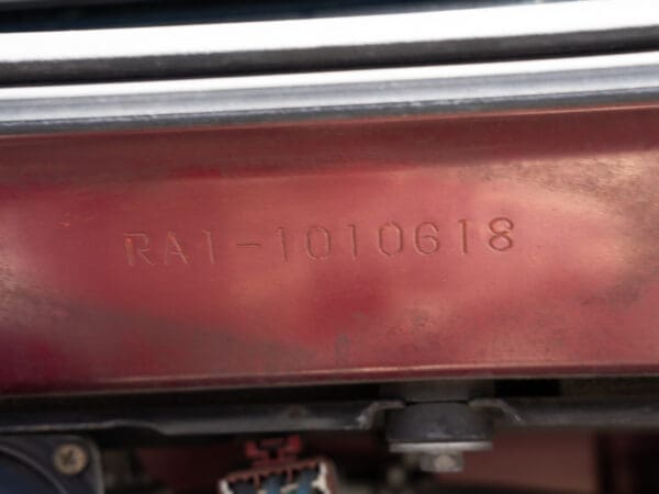 Red car part with serial number RAI-1010618.