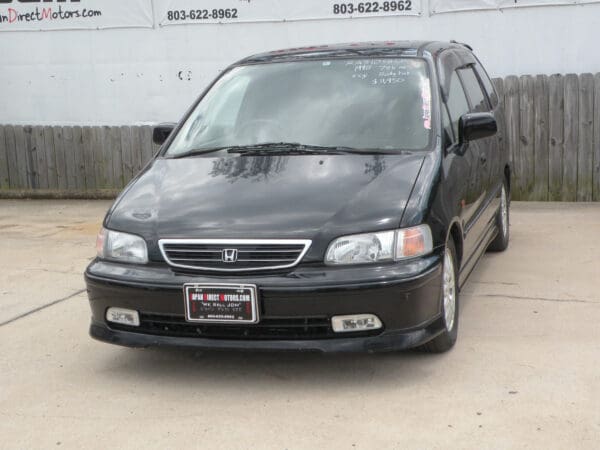 Black Honda Odyssey minivan front view.