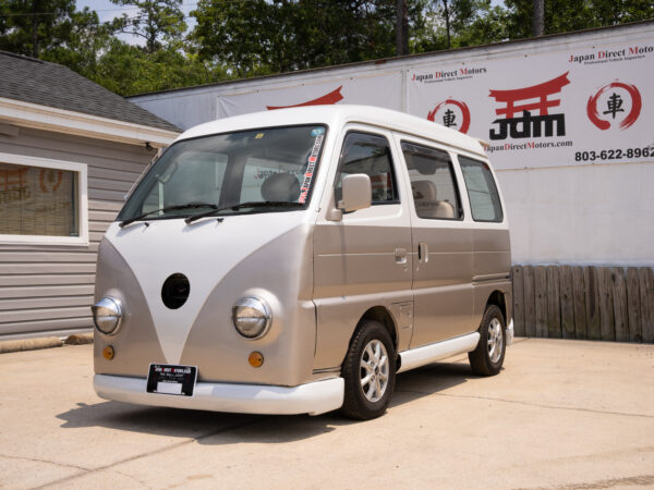 White and beige Japanese van parked outside.