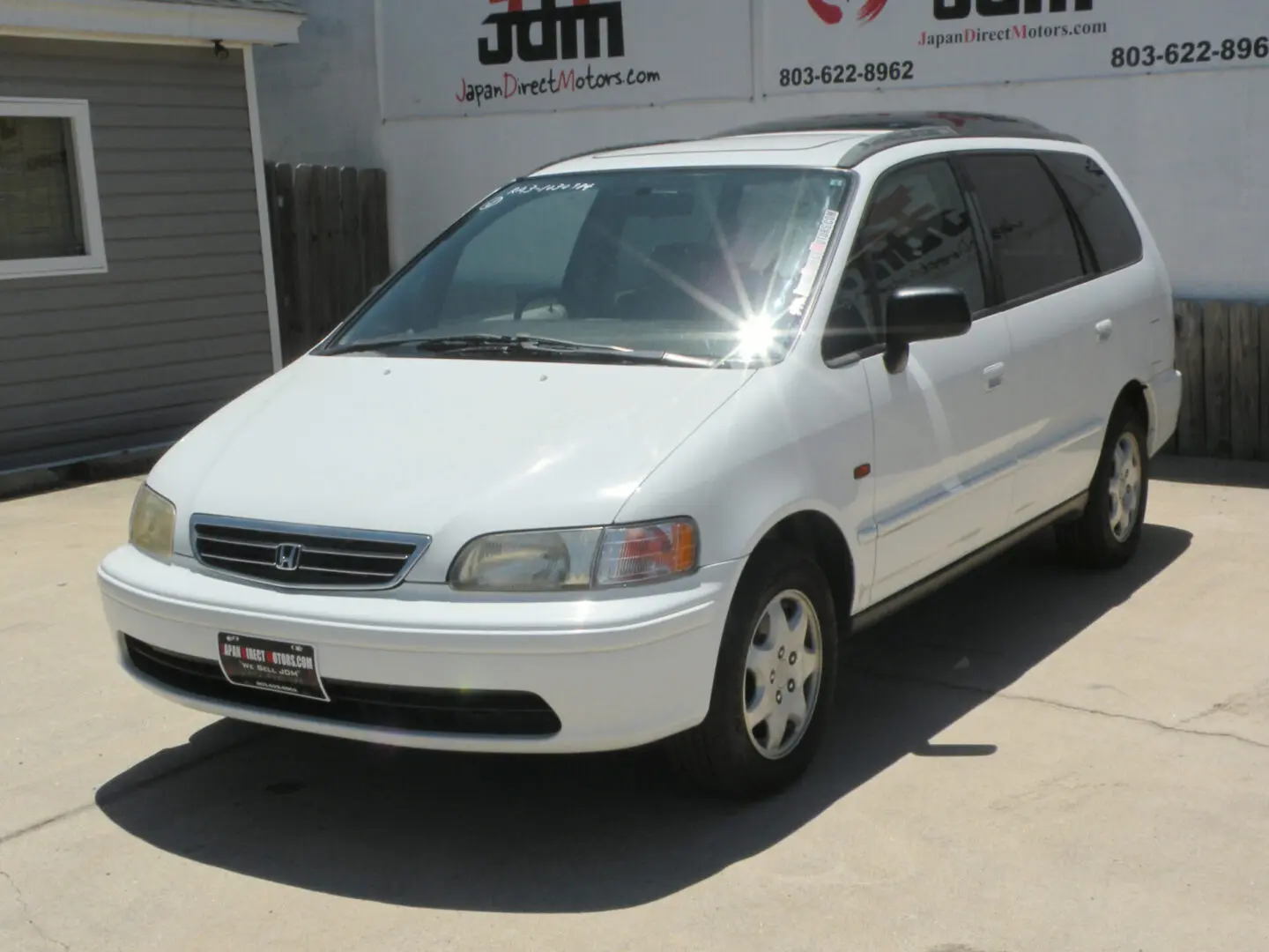 White Honda Odyssey minivan parked outside.