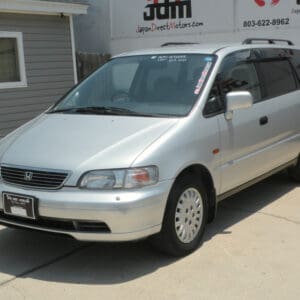 Silver Honda Odyssey minivan parked outdoors.