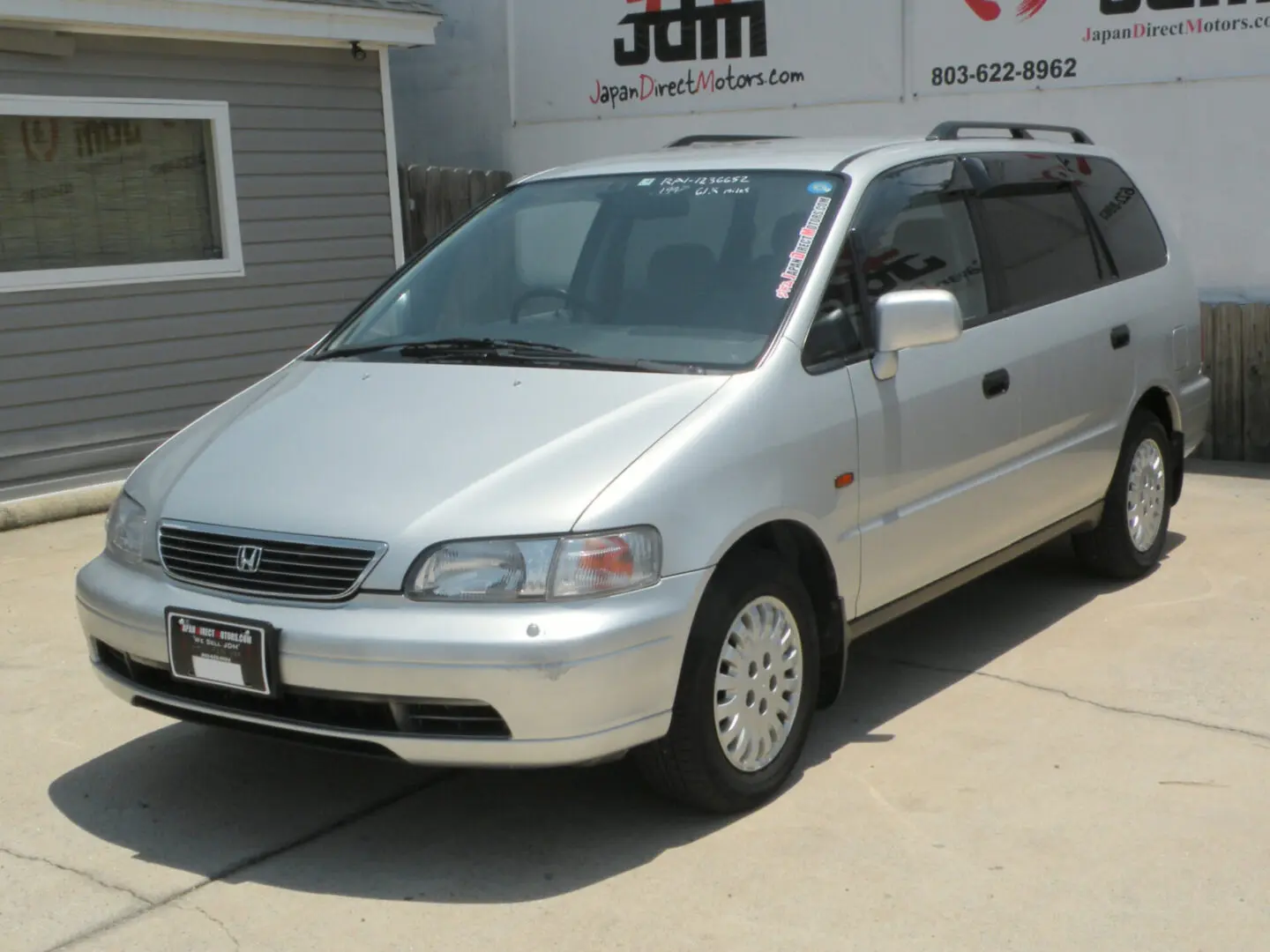 Silver Honda Odyssey minivan parked outdoors.