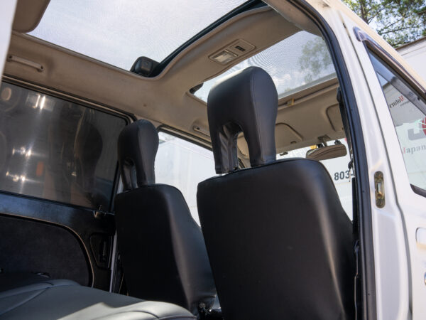 White car interior with sunroof and black seats.