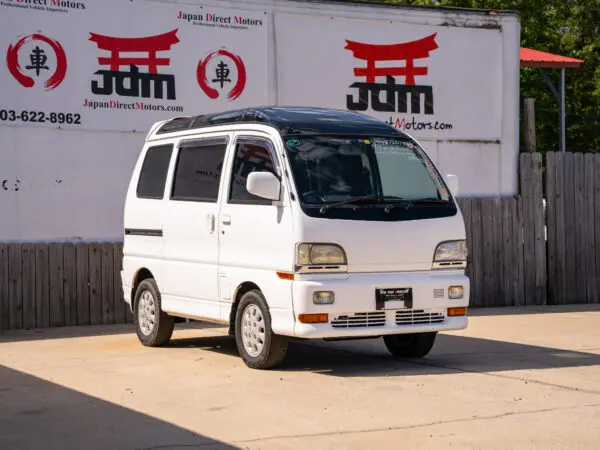 White van parked in front of Japan Direct Motors.