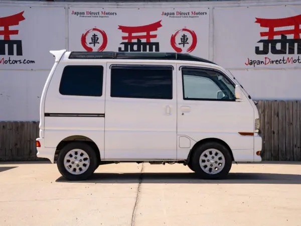 White Japanese minivan parked on asphalt.