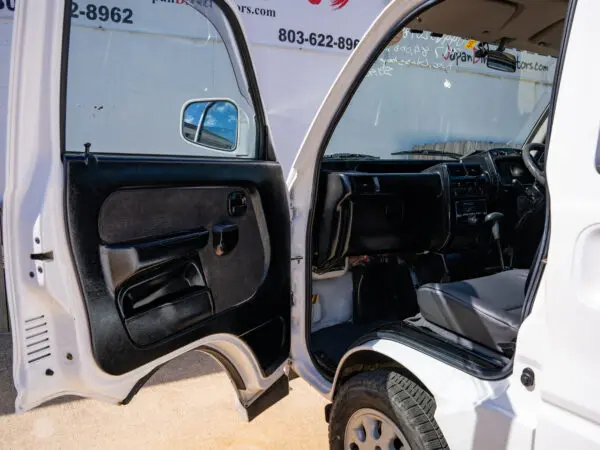 White van with open door and black interior.