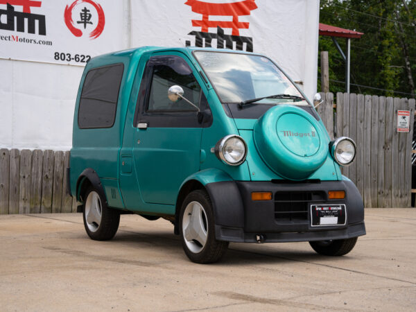 Green Midget II kei truck parked.