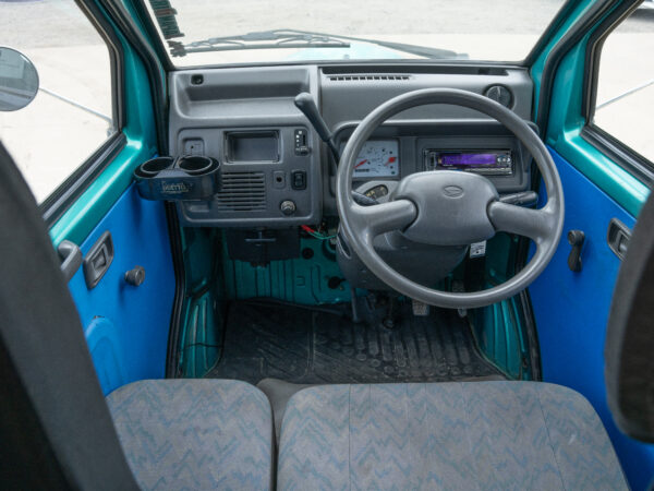 Green car interior with steering wheel.