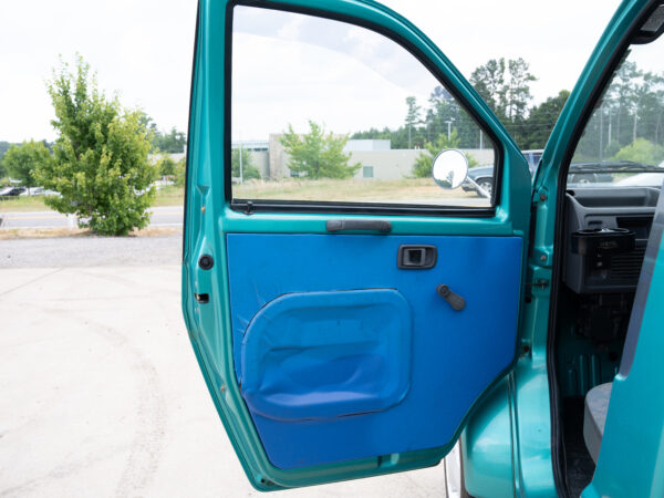 Open teal car door with blue paneling.