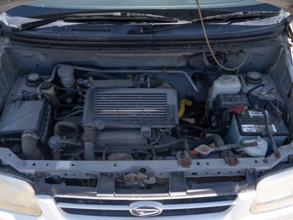 Open car hood with engine visible.