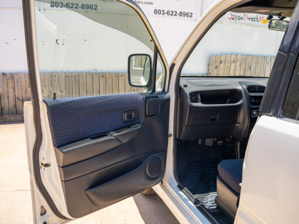 White car with open door and black interior.