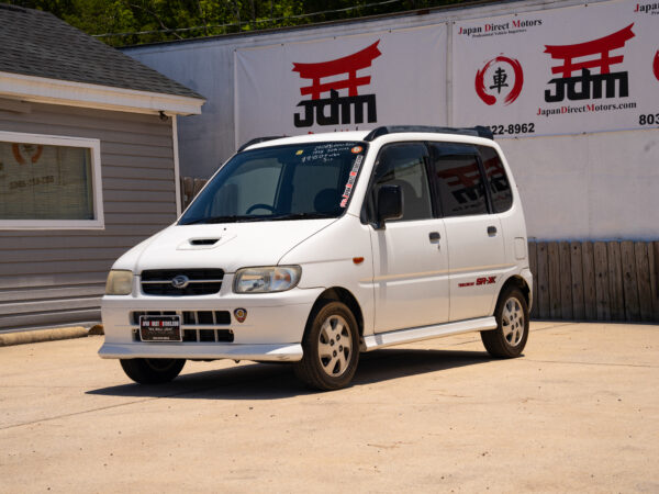 White Japanese car with red logo.