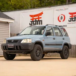 Blue Honda CR-V in front of dealership.