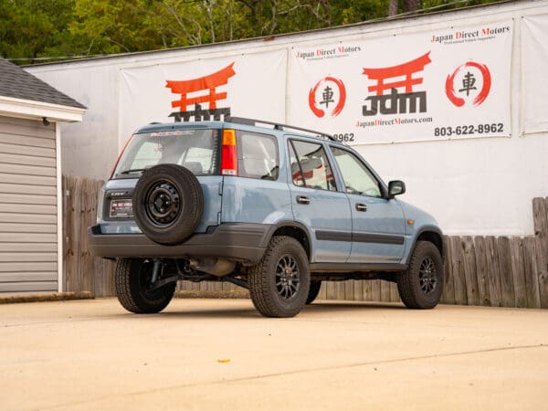 Blue Honda CR-V with spare tire.