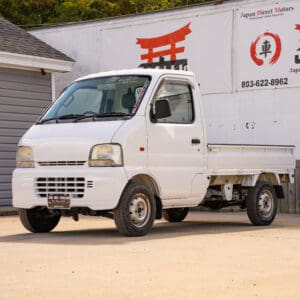 White Japanese mini truck parked outside.