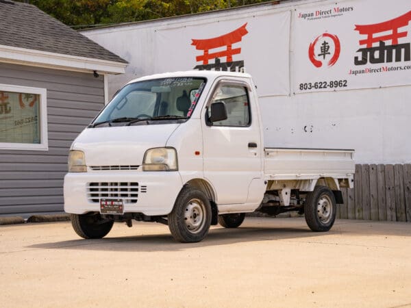 White Japanese mini truck parked outside.