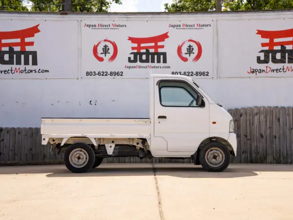 White Japanese mini truck parked outside.